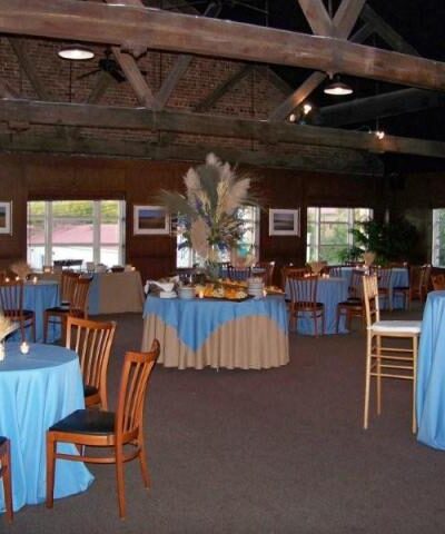 Event hall with blue tablecloths and chairs.