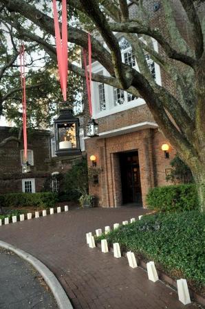 Brick building entrance with tree and lanterns.