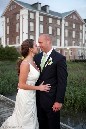 Bride and groom embracing near elegant building.