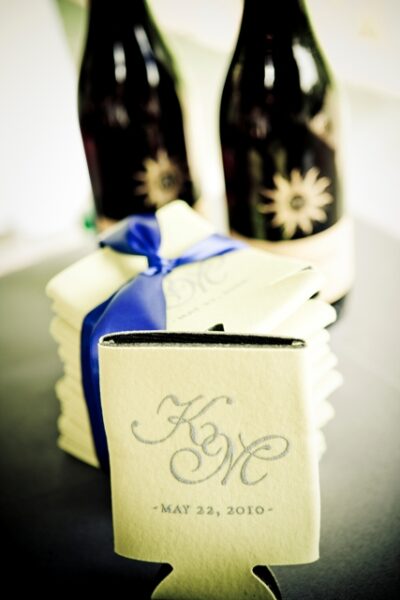 Wine bottles and personalized wedding koozies.