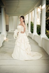 Bride in elegant gown under a colonnade.