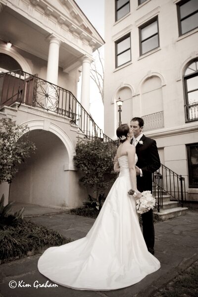 Bride and groom posing in an elegant outdoor setting.