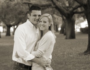 Couple embracing in a park setting.