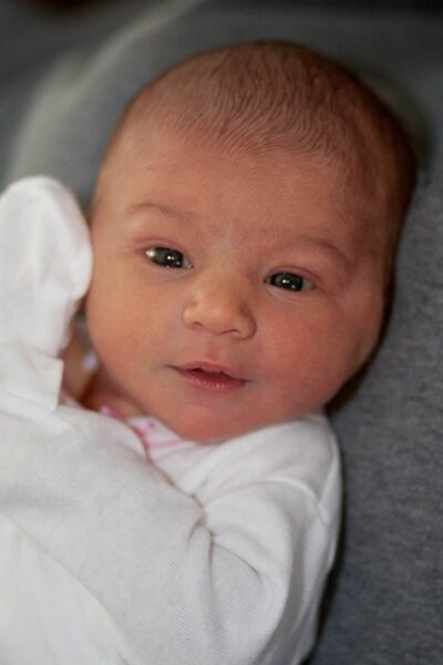 Newborn baby wrapped in a white blanket.