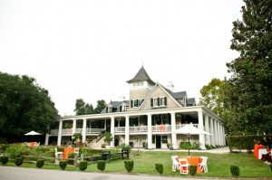 Large house with wraparound porch and garden.