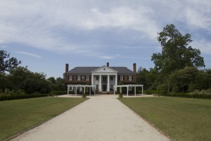Historic mansion with a long gravel path.
