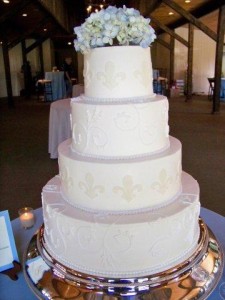 Elegant four-tiered wedding cake with flowers.