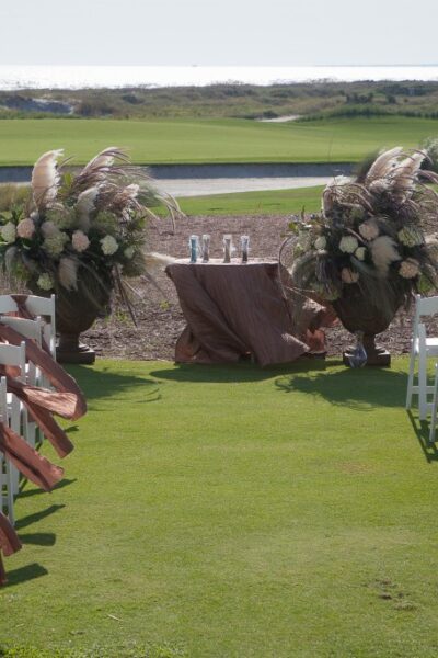 Outdoor wedding ceremony setup on golf course.