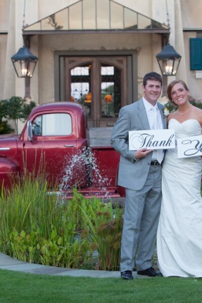 Bride and groom holding "Thank You" sign.