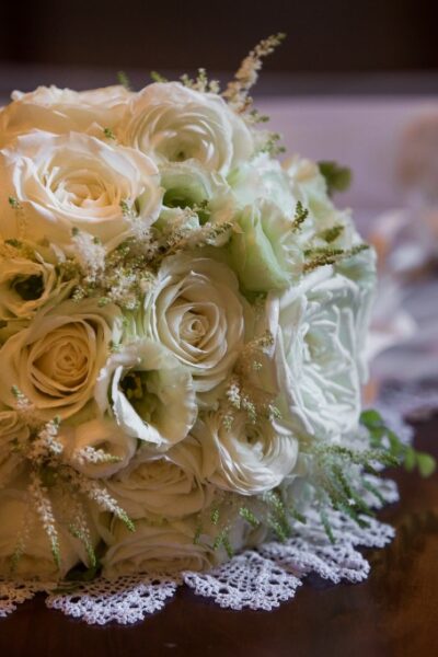 White rose bouquet on lace tablecloth.