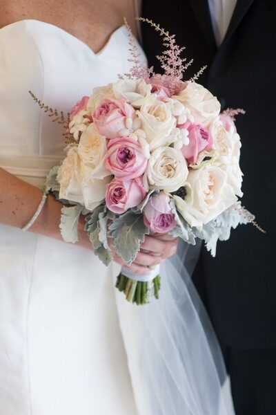 Bride holding a bouquet of pink and white roses.