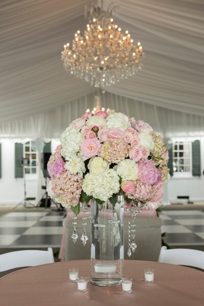Elegant bouquet of white and pink flowers in a glass vase at a formal event.
