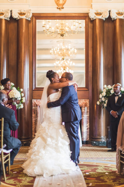 Bride and groom share a kiss at their wedding ceremony.
