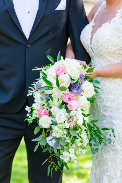 Bride and groom with a cascading floral bouquet on their wedding day.