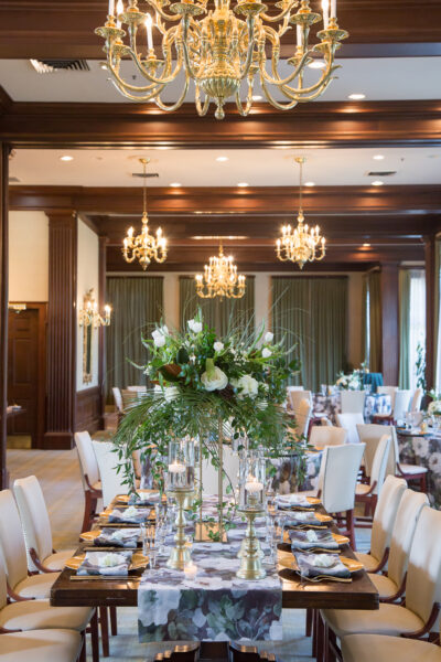 Elegant dining setup with chandeliers and floral centerpieces.