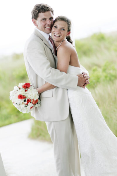 Bride and groom embracing outdoors on their wedding day.