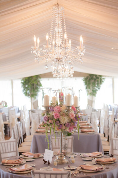 Elegant wedding reception setup with floral centerpieces and chandeliers.