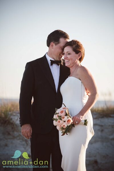 A groom kissing his bride on the forehead during their wedding.