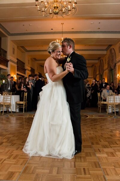 Bride and groom share their first dance in an elegant ballroom.