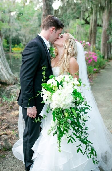 Bride holding a delicate bouquet of white and pastel flowers.