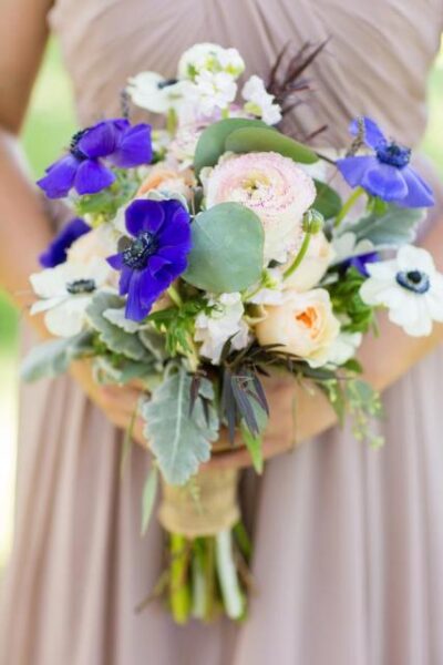 A delicate bridal bouquet with white and purple flowers.