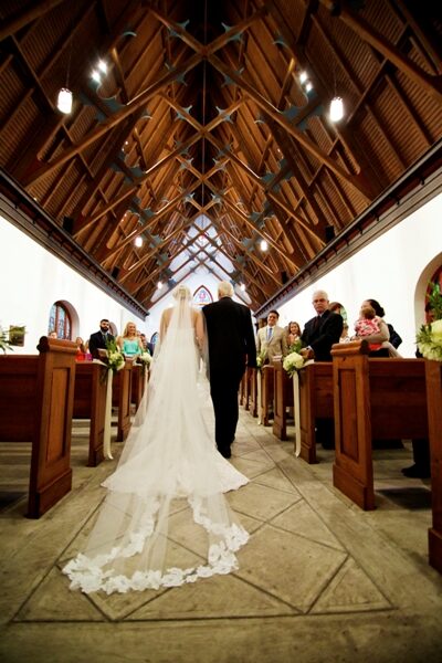 Bride and groom walking down the aisle in a church.