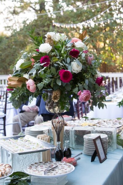 Elegant floral centerpiece with pink and burgundy roses at a formal event.