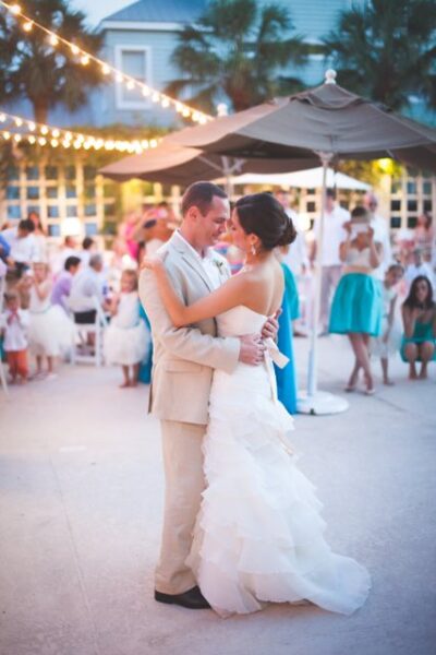 Newlyweds dance closely at an outdoor wedding reception.