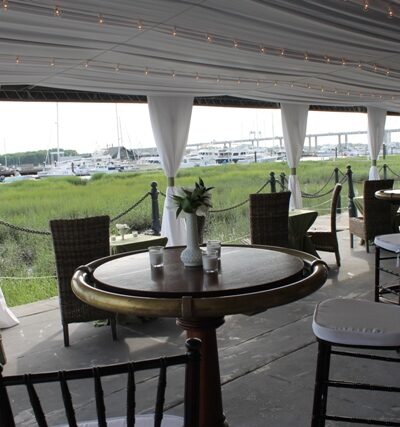 Outdoor seating area with tables and chairs under a covered patio.