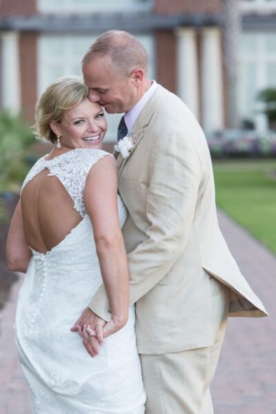 Bride and groom sharing a tender moment outdoors.