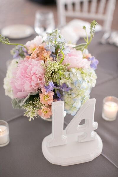 Elegant pastel floral centerpiece with a white table number 14.