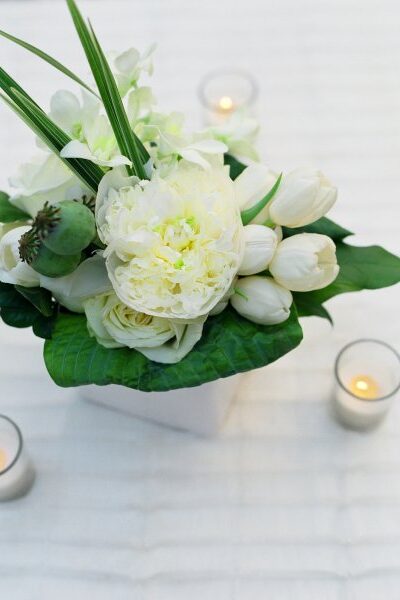 Elegant white floral centerpiece with candles.