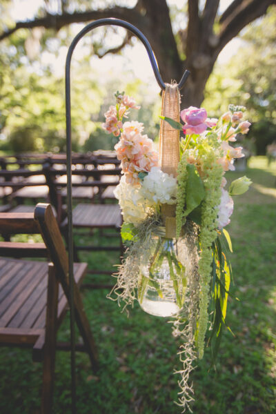 Beautiful floral arrangement in a mason jar at an outdoor event.