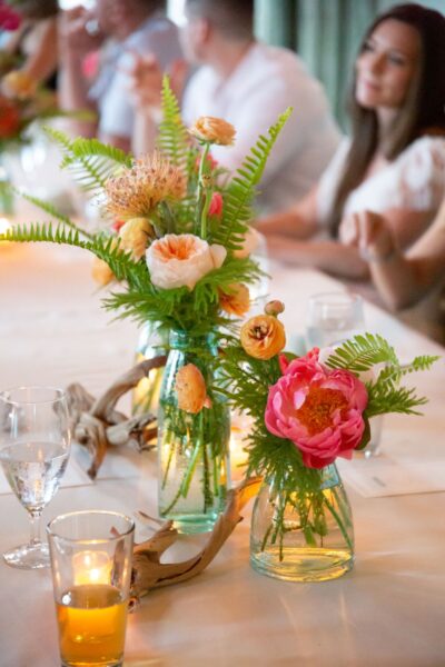 Elegant floral arrangements in glass vases on a dining table.