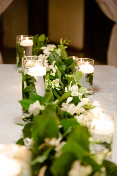 Elegant table centerpiece with floating candles and white flowers.