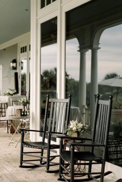 Rocking chairs on a porch overlooking a scenic view.