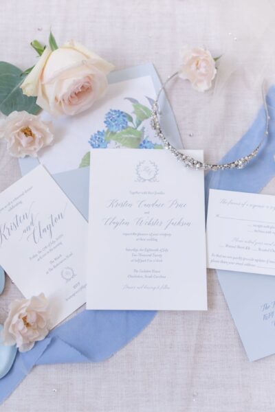 Elegant wedding invitation suite with floral and blue accents.