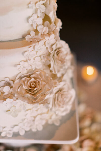 Elegant wedding cake adorned with detailed floral decorations.