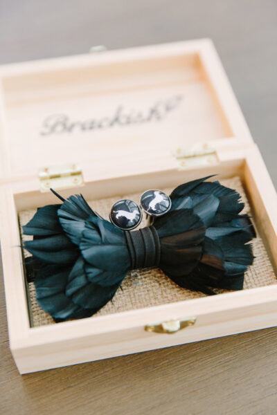 Elegant black feather bow tie in a wooden box.