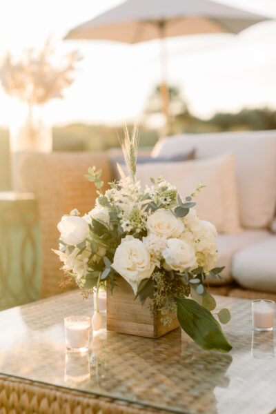 Elegant floral centerpiece in soft sunlight on a cozy outdoor table.