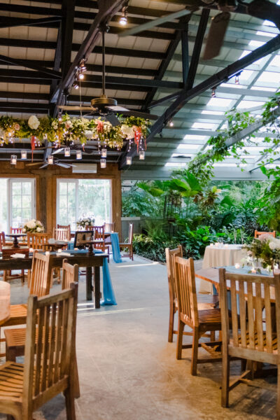 Cozy restaurant with wooden furniture and lush greenery.