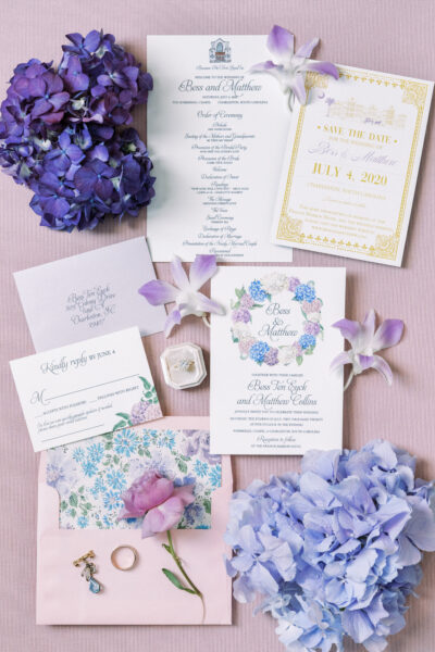 Elegant blue and purple floral wedding invitations with matching hydrangeas.