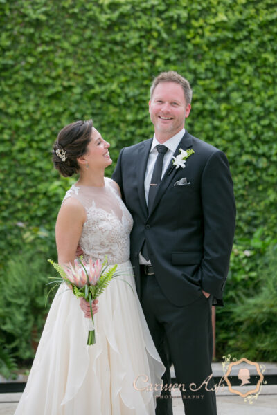 Bride and groom smiling together outdoors on their wedding day.