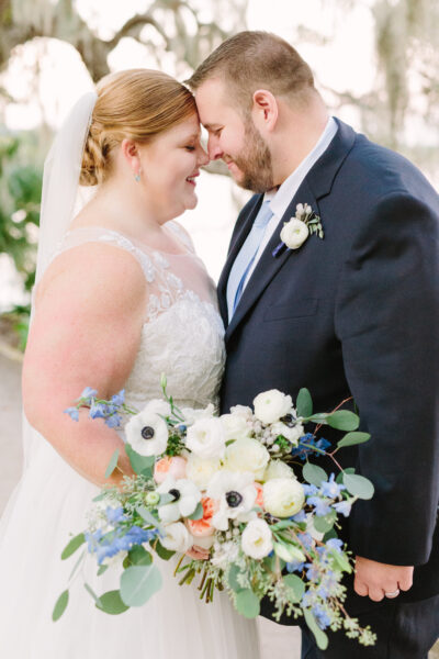 Bride and groom intimately embracing at their wedding with a beautiful floral bouquet.