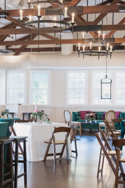 Bright rustic dining area with wooden beams and green tablecloths.