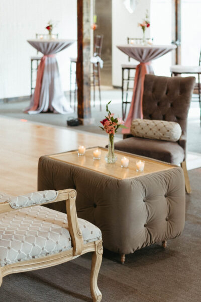 Cozy seating area with elegant chairs and a tufted ottoman in a bright room.