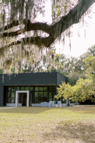 Modern glass building in a serene, green park setting.