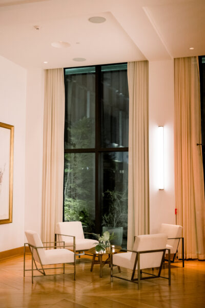 Cozy sitting area with tall window and warm lighting.