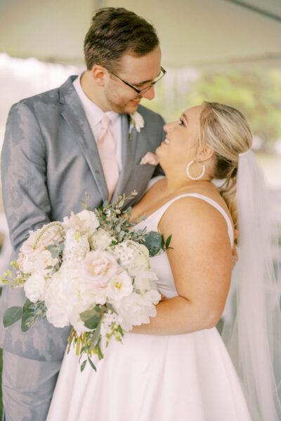 Happy bride and groom sharing a loving moment with a bouquet.