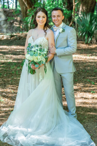 Bride and groom posing outdoors on their wedding day.
